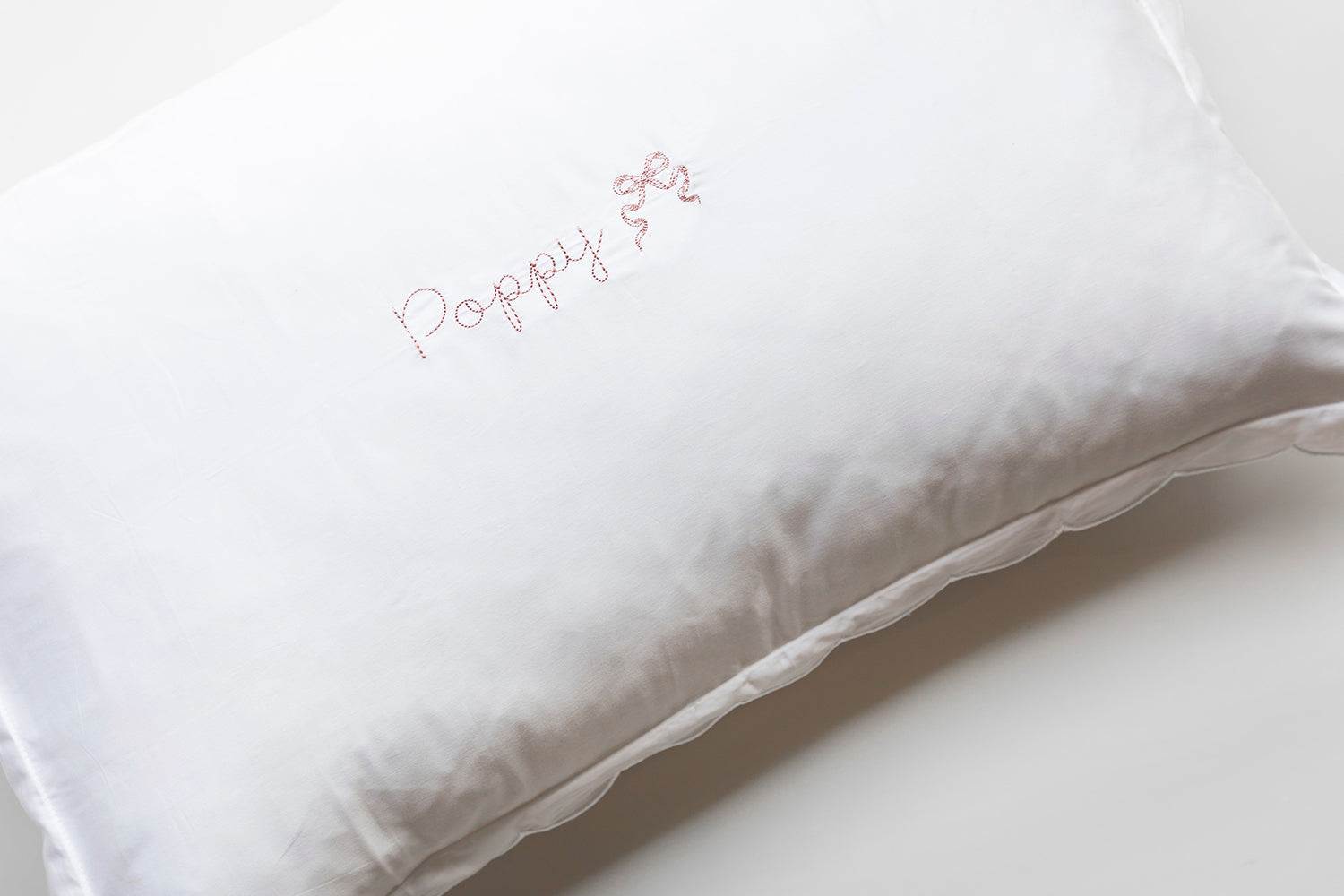 Organic cotton toddler pillowcase with blush scalloped edge and personalized embroidery.