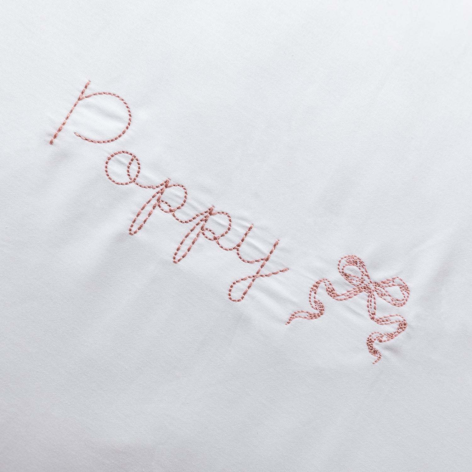 Organic cotton pillowcase with white scalloped edge and personalized embroidery.