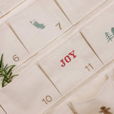 Embroidered Advent Calendar on ivory cotton canvas with festive designs and personalized text pockets.