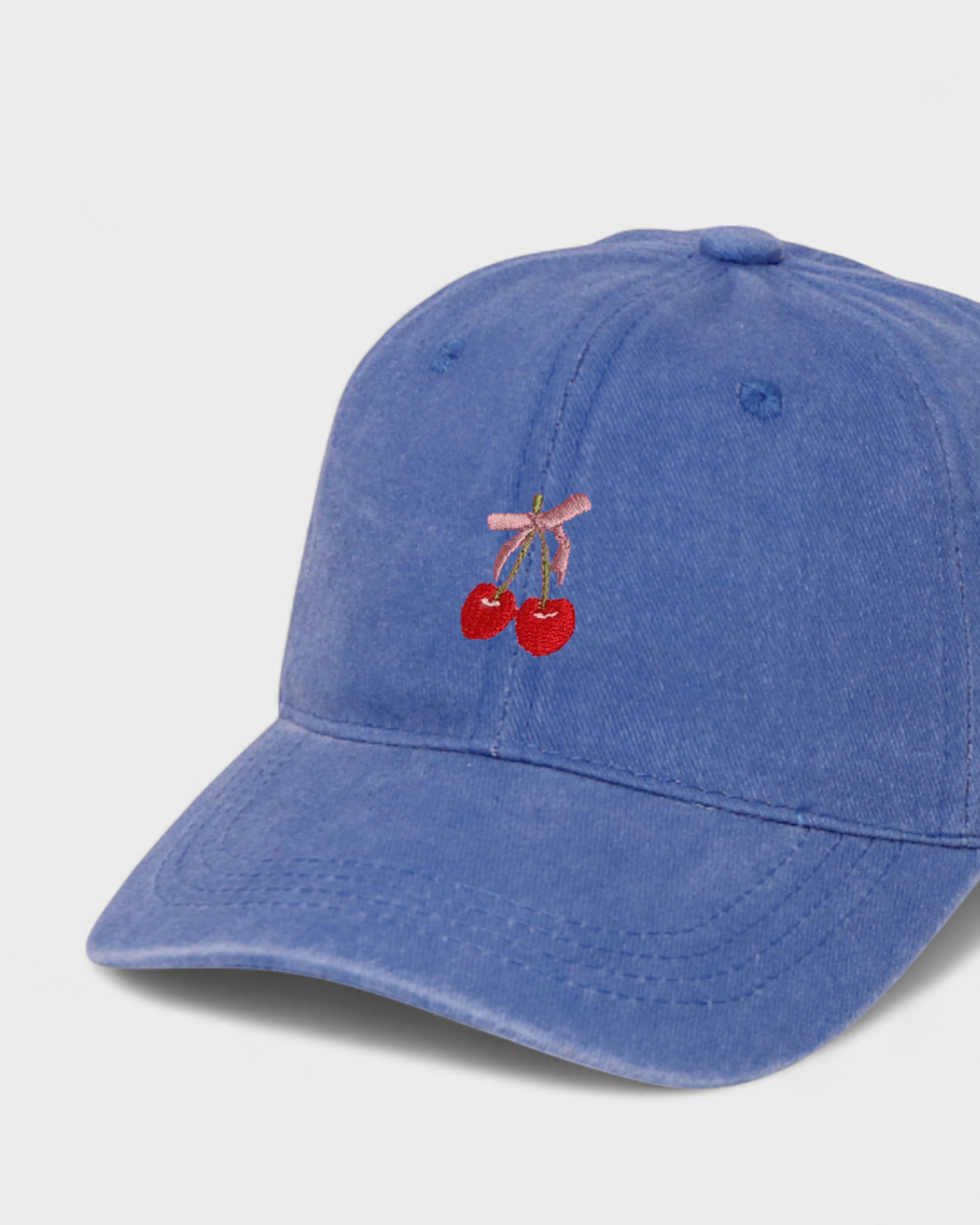 Blue personalised hat with embroidered cherries and pink bow design.