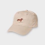 Beige personalised hat with hand-embroidered brown Dachshund design on front, made of 100% washed cotton in classic baseball style.