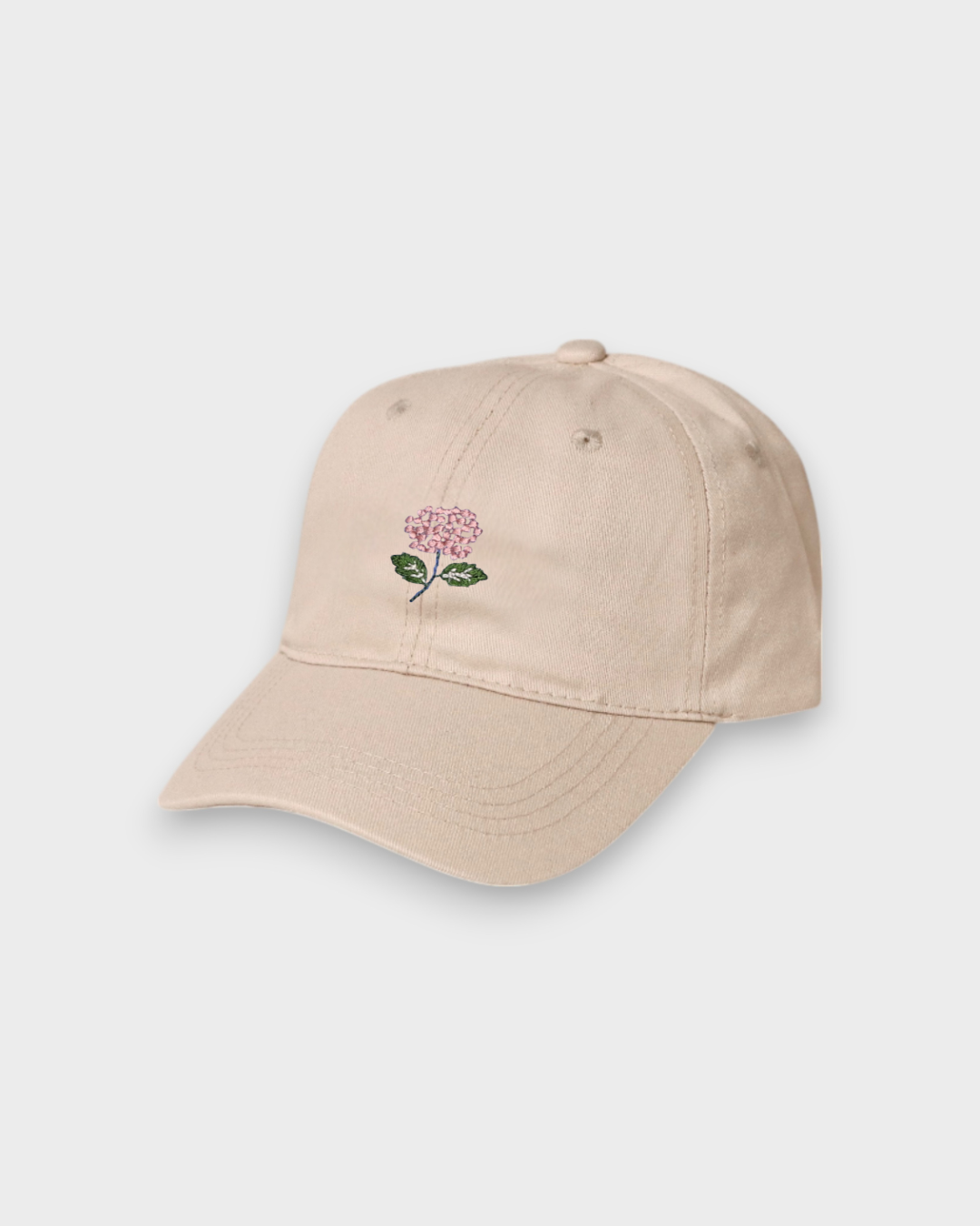 Beige personalised hat with hand-embroidered pink hydrangea design on front, made of 100% washed cotton with classic baseball fit