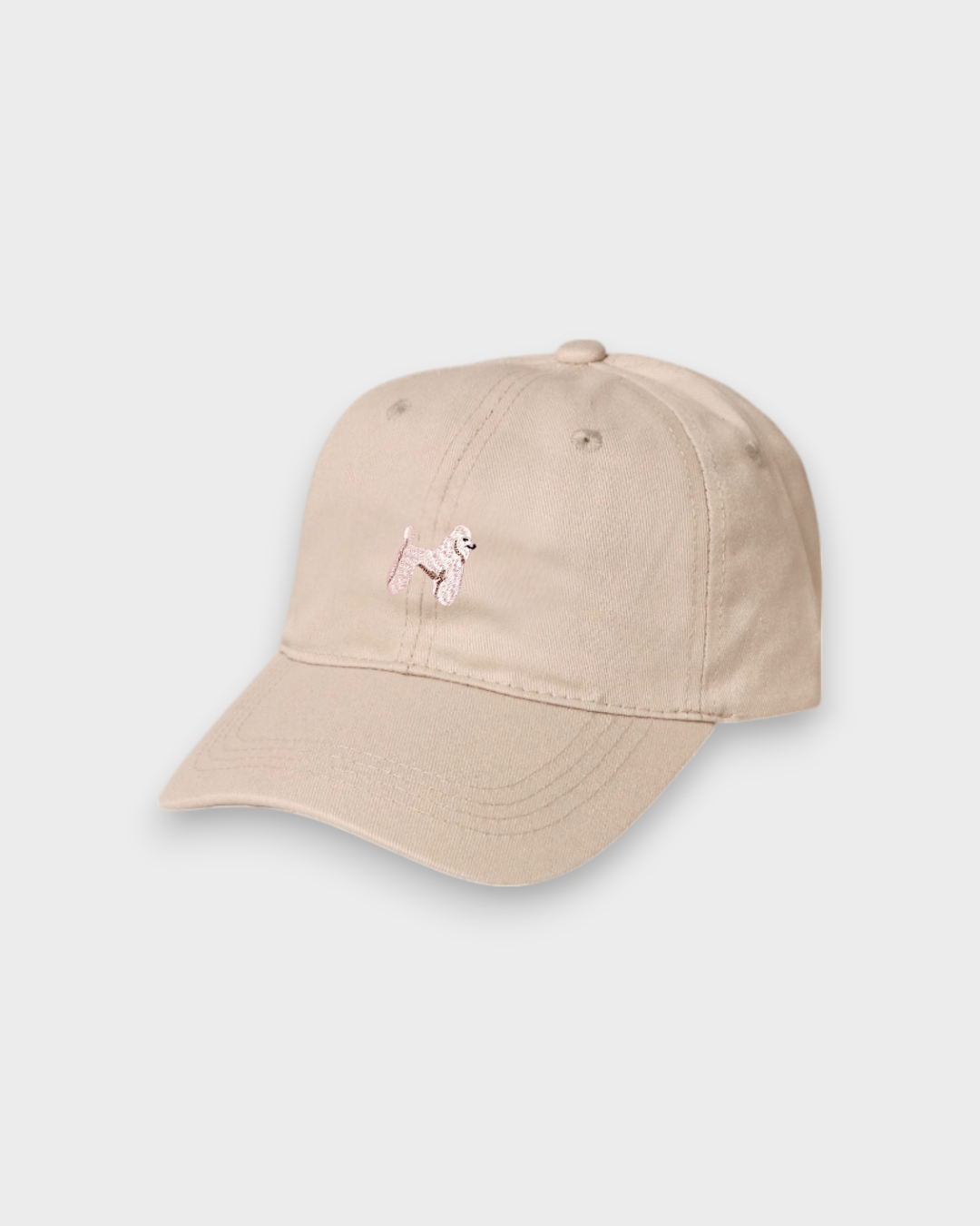 Beige baseball cap with embroidered hand-drawn pink poodle design, personalised embroidery option, made of 100% washed cotton.