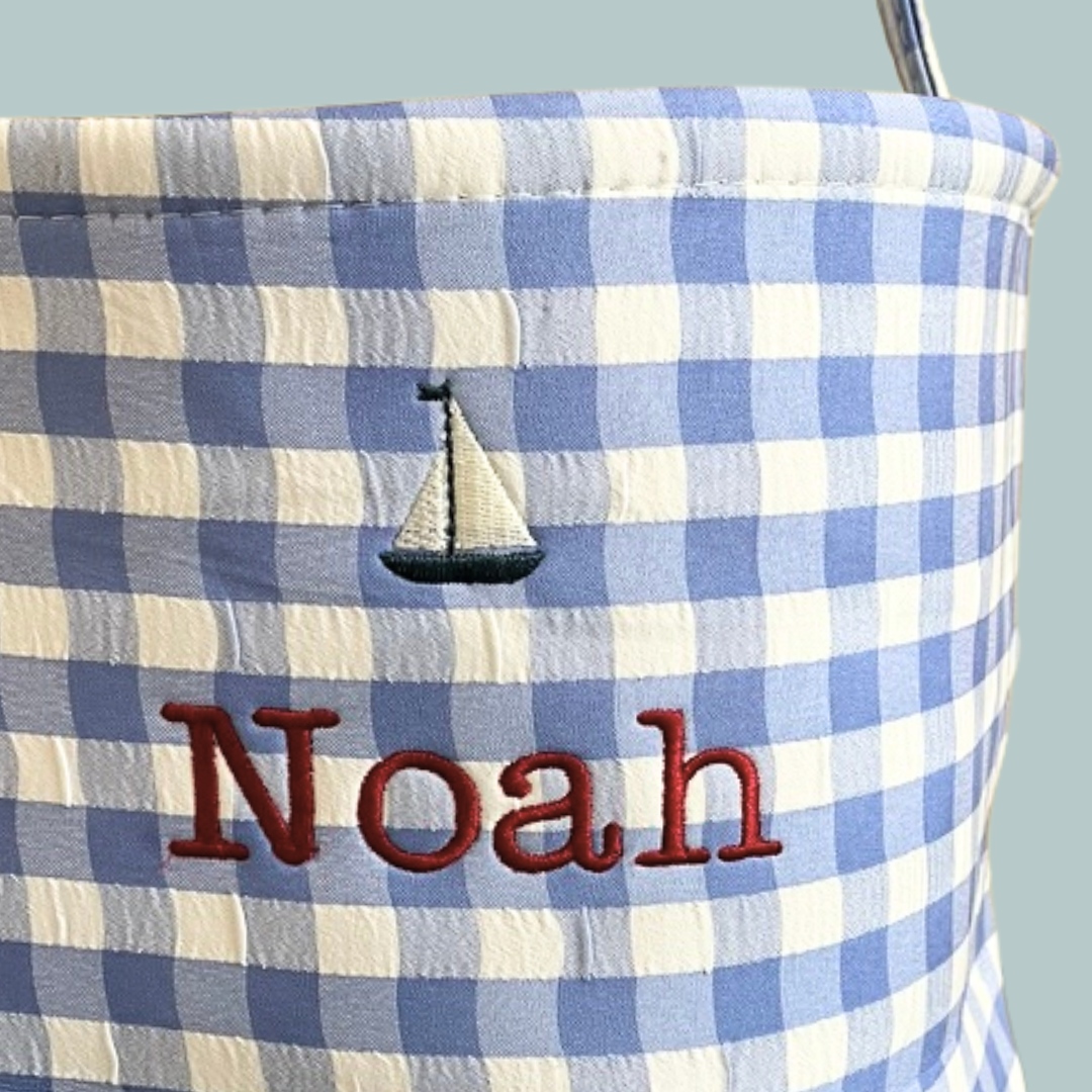 Personalised Easter bucket with sailboat embroidery on blue gingham fabric.