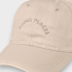 Personalised baseball cap with embroidered "Going Places" text on beige cotton.
