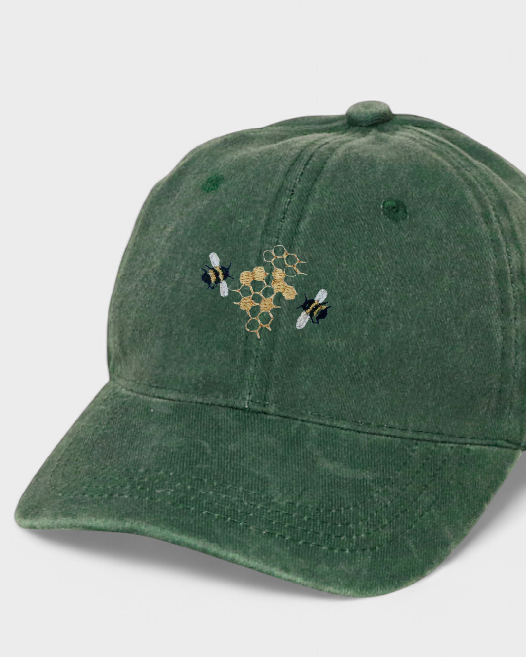 Green baseball cap with embroidered bee and honeycomb design, crafted from 100% washed cotton, available in personalized text options.