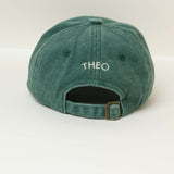 Green personalised hat with embroidered name "THEO" on the back, made of 100% washed cotton.