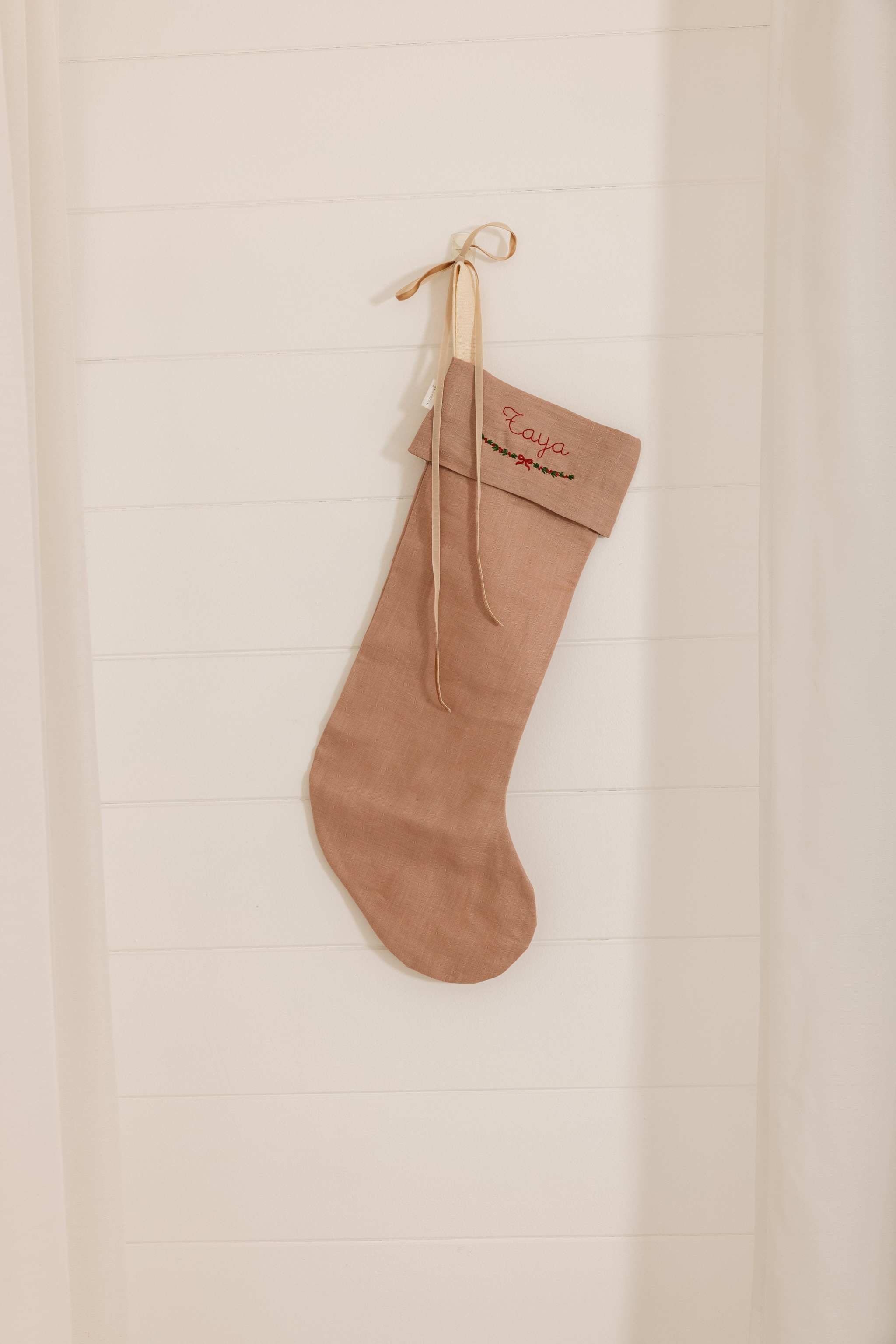 handmade personalized linen Christmas stocking in natural color hanging on wall