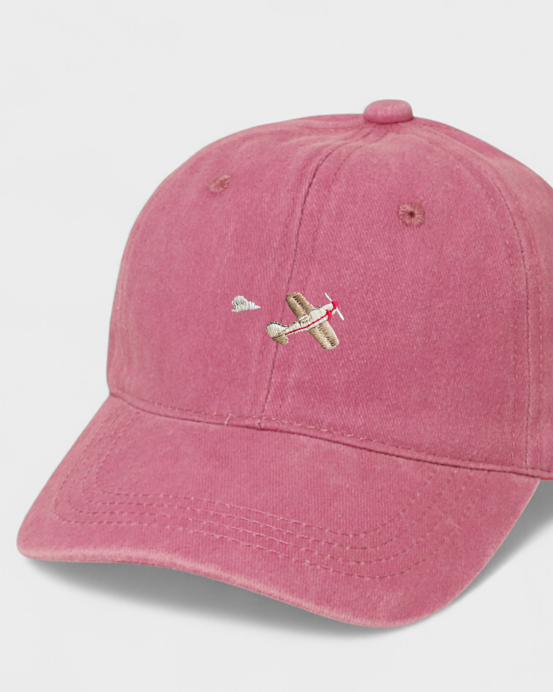 Airplane personalised hat with embroidered design on the front in pink color, made of 100% washed cotton.