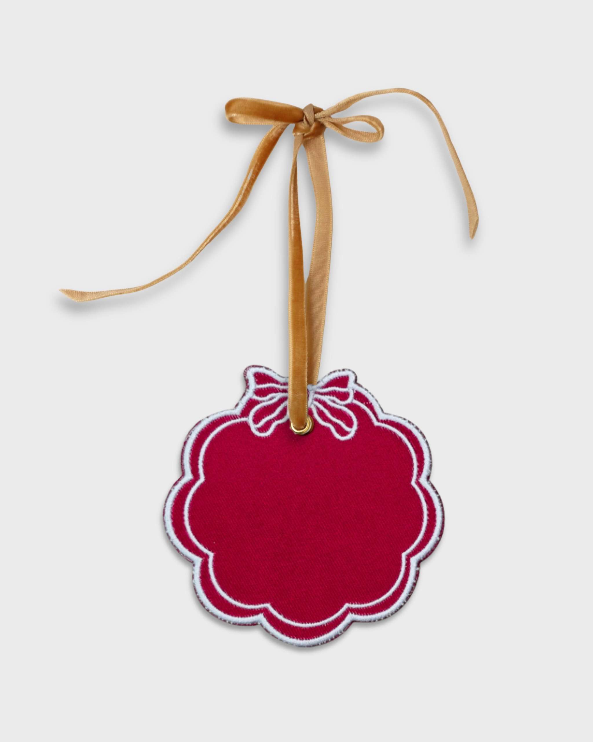 Red scalloped pet ornament with white embroidered bow and gold velvet hanging ribbon