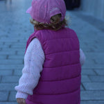 Child wearing a pink Bees Personalised Hat with a custom name embroidered on the back.