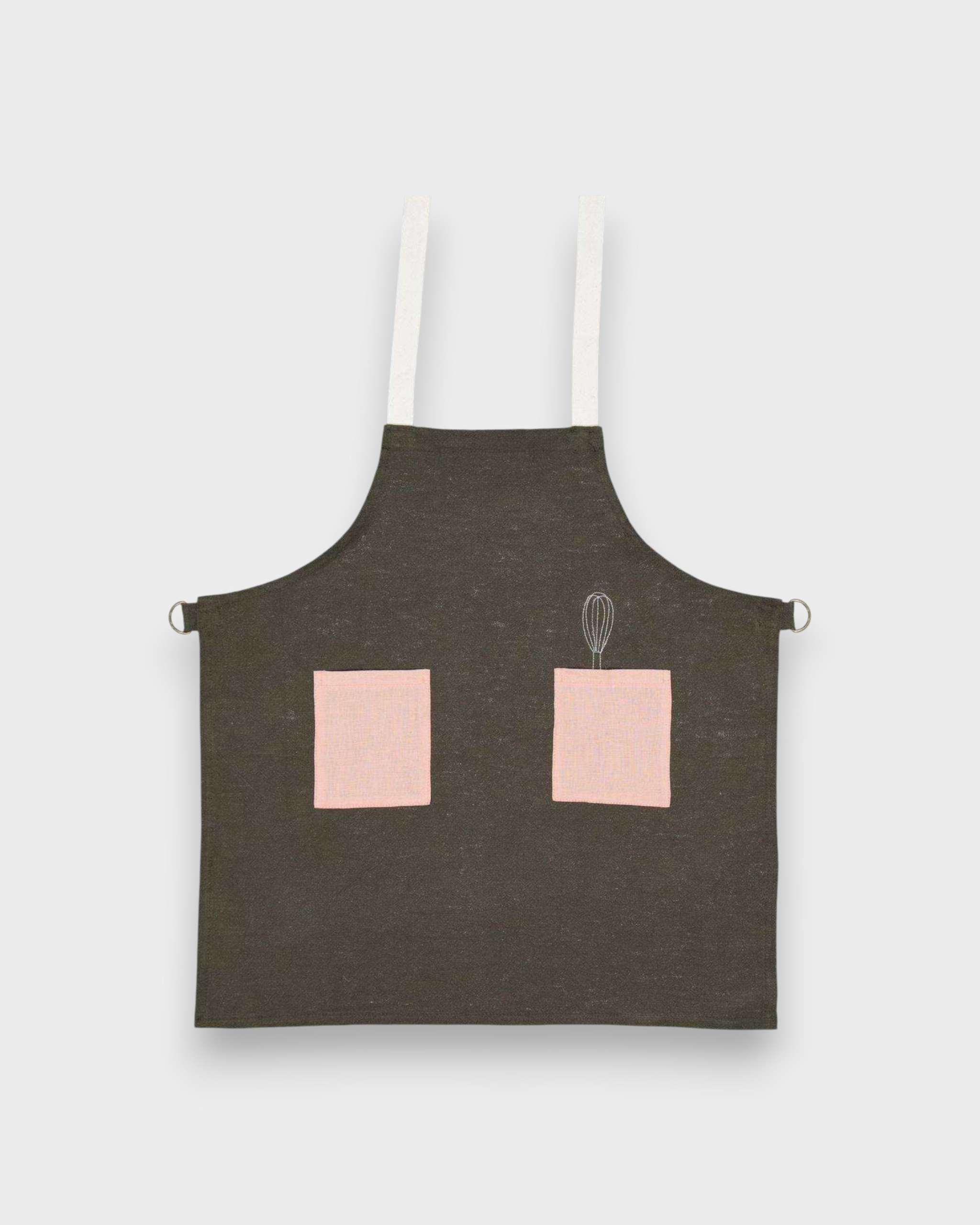Kids forest green linen apron with pink pockets and adjustable straps.